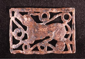 © Seine et Yvelines Archéologie / EPI Yvelines-Hauts-de-Seine Objet archéologique en métal, représentant un animal stylisé entouré de motifs géométriques, probablement une boucle de ceinture ou un élément décoratif